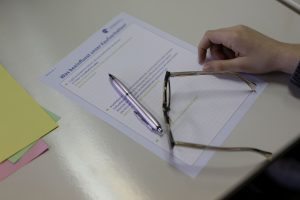 SChüler sitzt vor dem Arbeitsblatt: Was beeinflusst unser Kaufverhalten.
