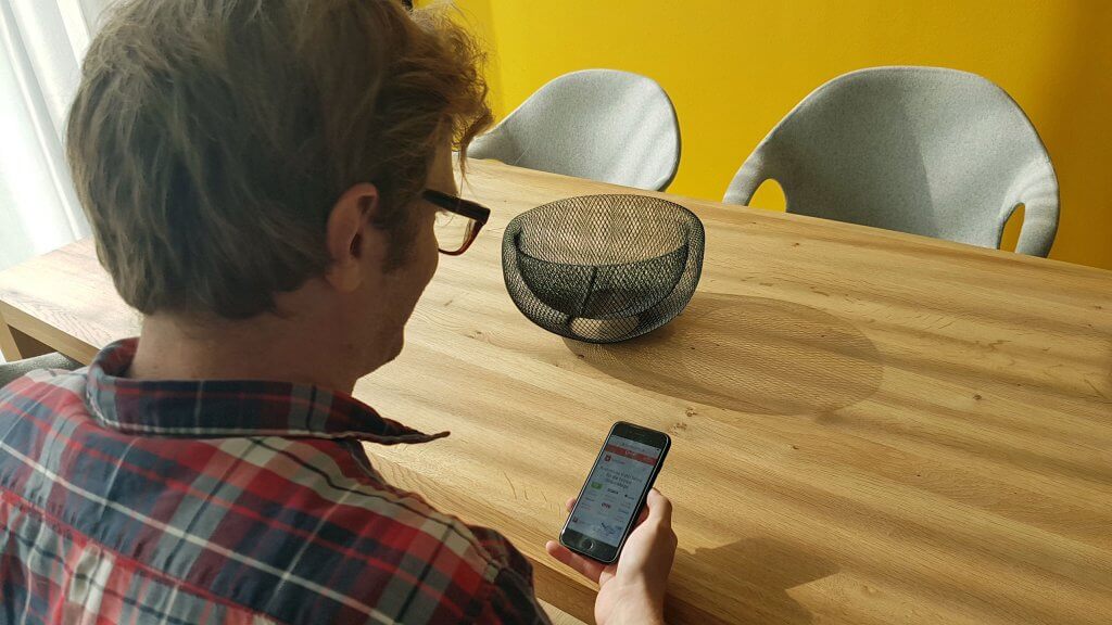 Junger Mann vergleicht auf dem Handy Preise.