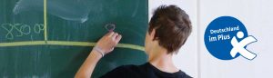 SChüler erstellt Budgetplan an einer Tafel.