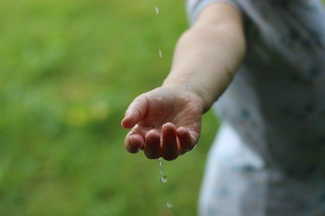 Hand unter Wasserstrahl