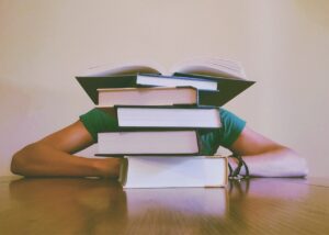 STudent hinter Büchern versteckt