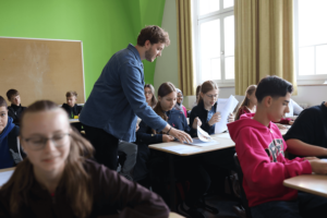 Referent teilt Arbeitsblätter aus.